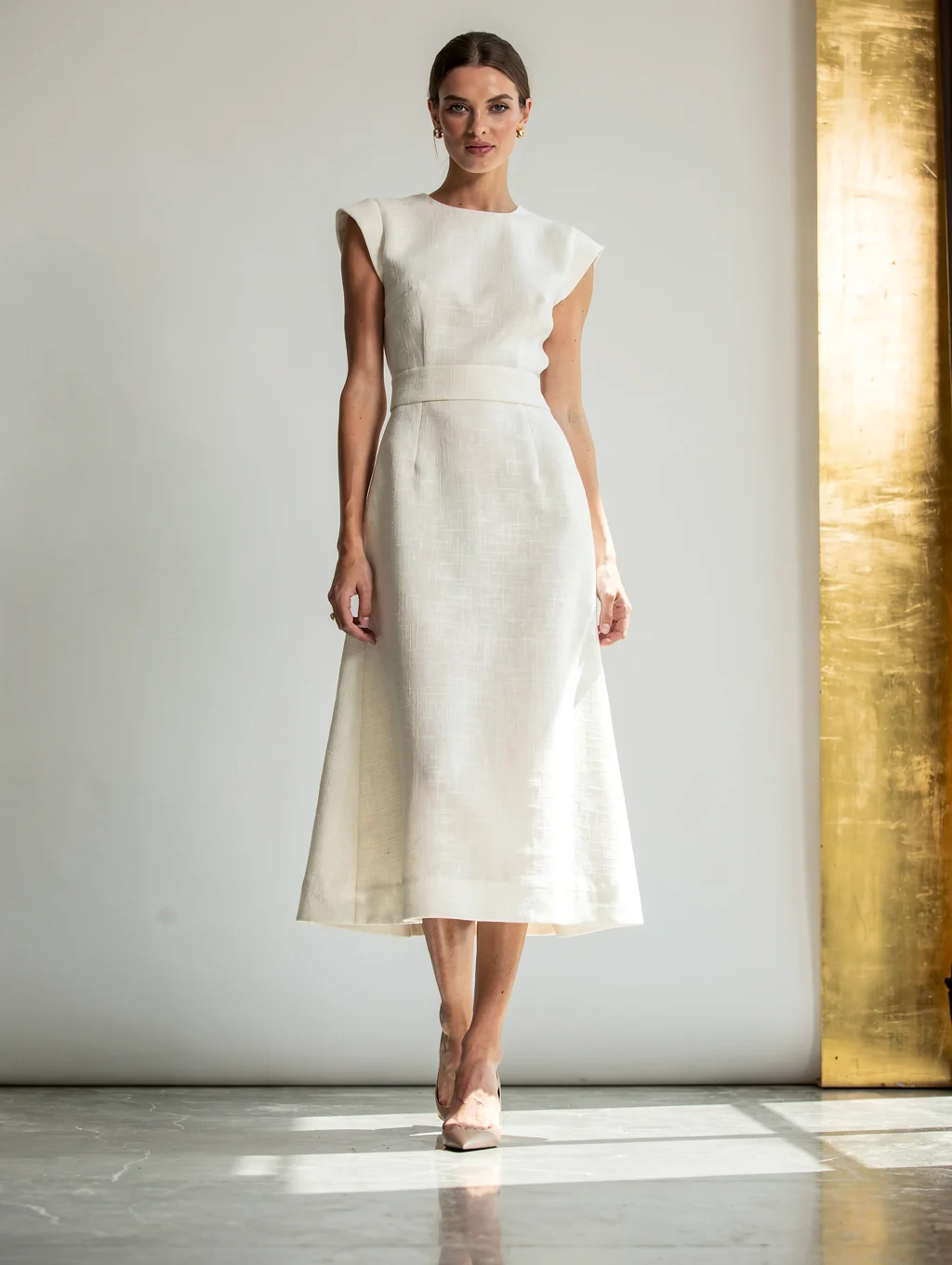 Model wearing midi dress with soft architectural lines